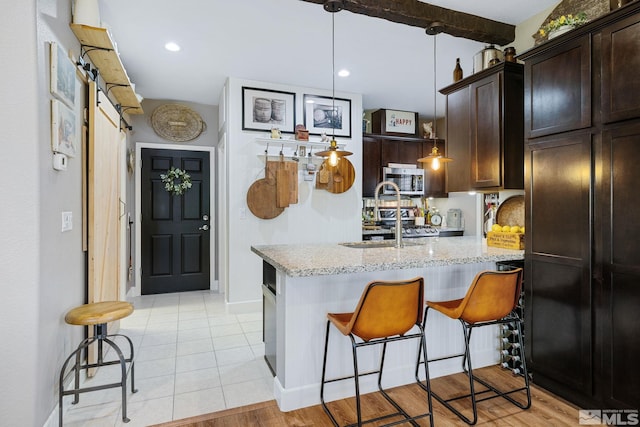 958 Marble Hills Cir, Sparks, NV 89436 - kitchen with a sink, light stone countertops, a peninsula, dark brown cabinets, and recessed lighting