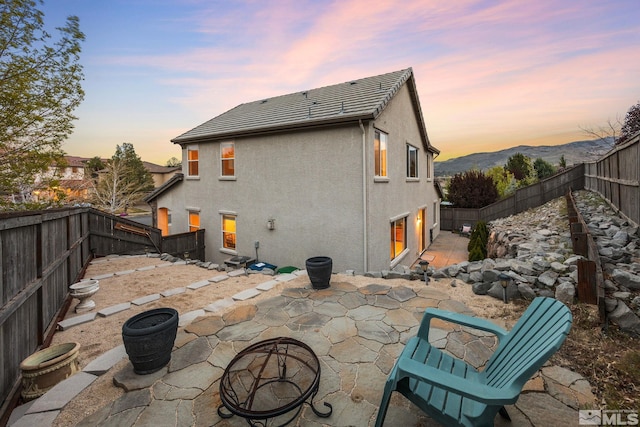 7150 Provence Cir, Reno, NV 89523 - back of property at dusk featuring a patio, a fenced backyard, and stucco siding