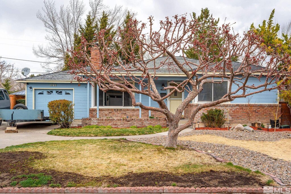 1745 California Ave, Reno, NV 89509 - ranch-style home featuring an attached garage, concrete driveway, and brick siding