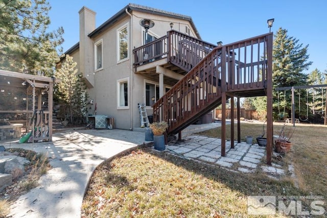 4531 Pyramid Peak Cir, Sparks, NV 89436 - rear view of house featuring a patio, stucco siding, a chimney, and a wooden deck