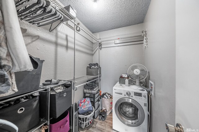 laundry room with washer / dryer, wood finished floors, and a textured ceiling