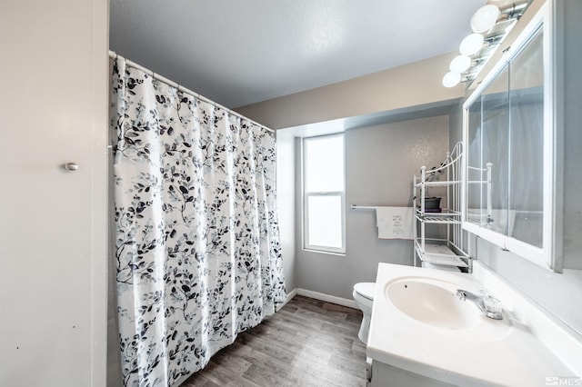 full bath with toilet, wood finished floors, baseboards, vanity, and a shower with shower curtain