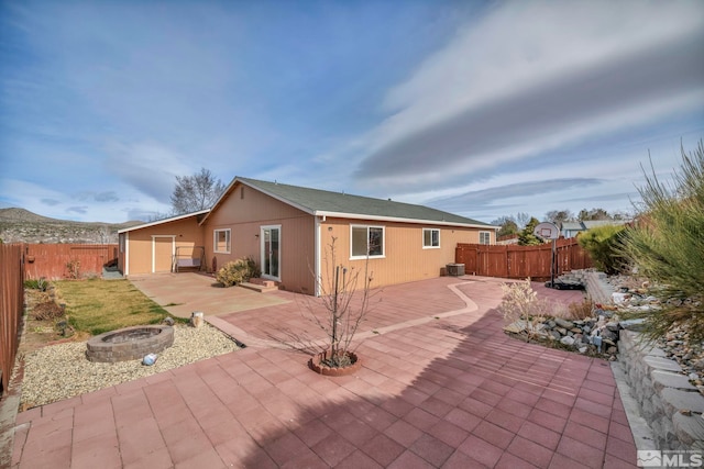 5620 Tassel Dr, Sun Valley, NV 89433 - back of house featuring an outdoor fire pit, a patio area, and a fenced backyard
