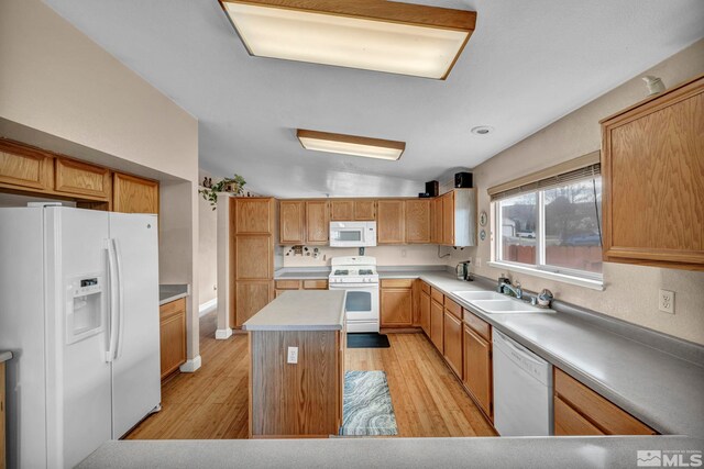 5620 Tassel Dr, Sun Valley, NV 89433 - kitchen featuring white appliances, light wood-style flooring, a sink, a kitchen island, and lofted ceiling
