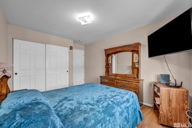 5620 Tassel Dr, Sun Valley, NV 89433 - bedroom with light wood finished floors, a textured ceiling, a closet, and baseboards