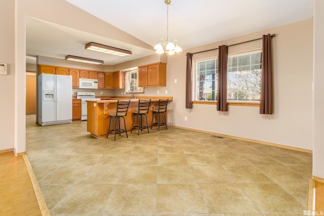5925 Arvilla Ln, Fallon, NV 89406 - kitchen featuring white appliances, a peninsula, a sink, a chandelier, and vaulted ceiling