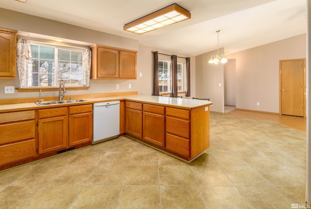5925 Arvilla Ln, Fallon, NV 89406 - kitchen with a sink, dishwasher, a peninsula, light countertops, and brown cabinetry