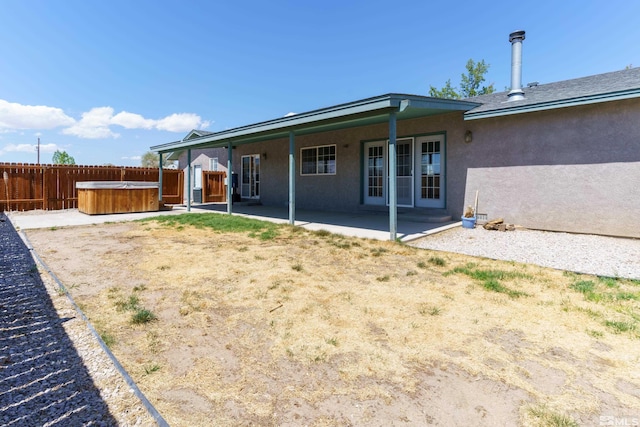 5925 Arvilla Ln, Fallon, NV 89406 - rear view of property featuring a hot tub, fence, stucco siding, and a patio area