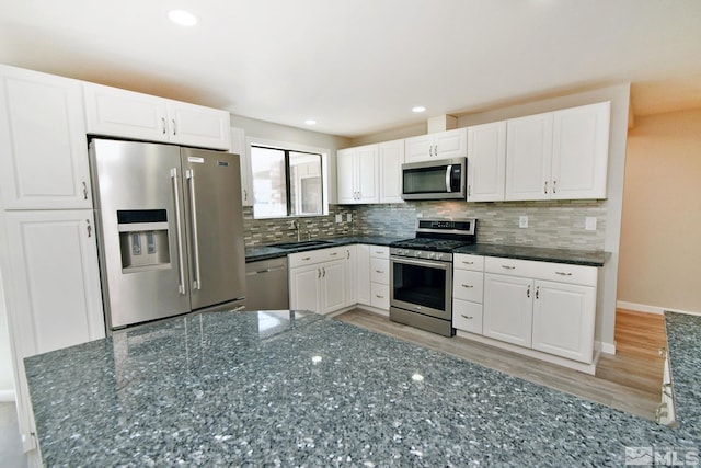 916 Tillman Ln, Gardnerville, NV 89460 - kitchen with stainless steel appliances, a sink, light wood-style flooring, white cabinetry, and recessed lighting