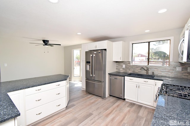916 Tillman Ln, Gardnerville, NV 89460 - kitchen featuring appliances with stainless steel finishes, a sink, ceiling fan, light wood-style flooring, and decorative backsplash