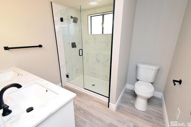 916 Tillman Ln, Gardnerville, NV 89460 - bathroom with wood finished floors, a marble finish shower, toilet, double vanity, and baseboards