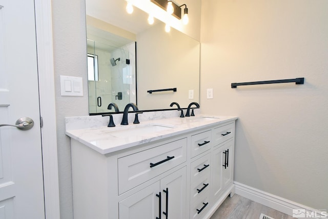 916 Tillman Ln, Gardnerville, NV 89460 - full bath featuring a stall shower, double vanity, wood finished floors, and baseboards