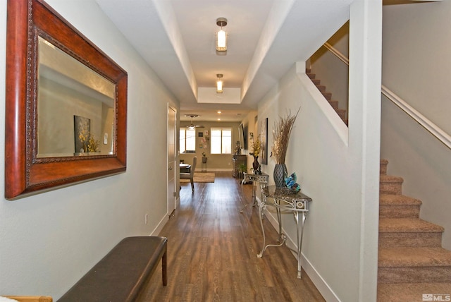 corridor with stairs, wood finished floors, and baseboards