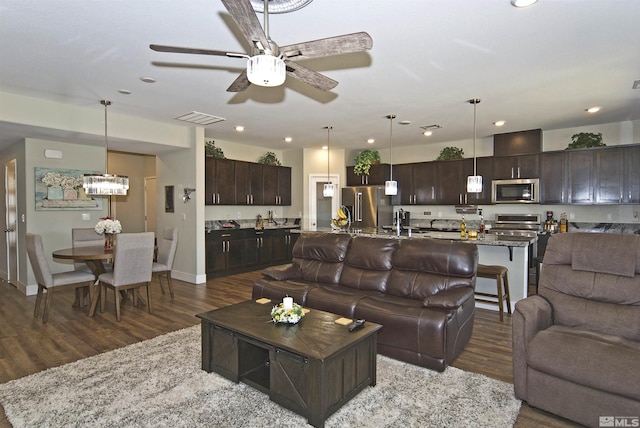 living room featuring wood finished floors, ceiling fan, recessed lighting, and baseboards