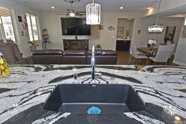 living area featuring a chandelier, ceiling fan, recessed lighting, and wood finished floors