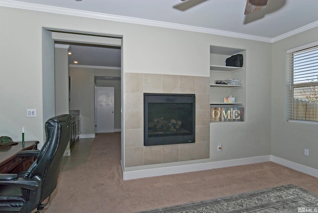 carpeted living area featuring ornamental molding, a fireplace, baseboards, built in features, and a ceiling fan