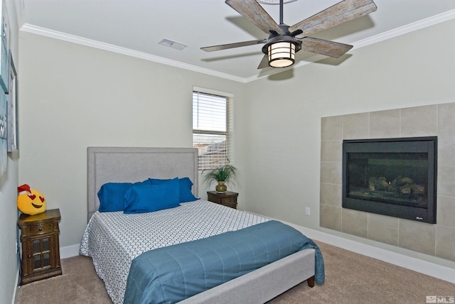bedroom with carpet, crown molding, a ceiling fan, a tile fireplace, and baseboards