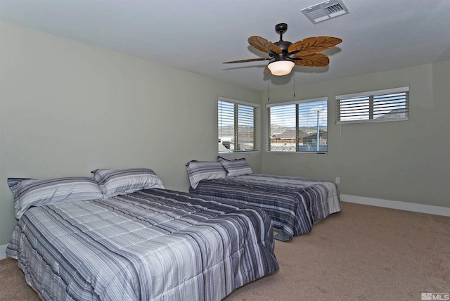 bedroom with light colored carpet, baseboards, and a ceiling fan