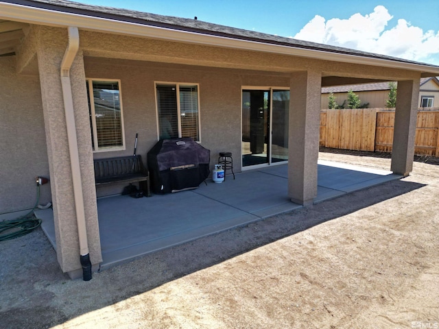view of patio featuring area for grilling and fence