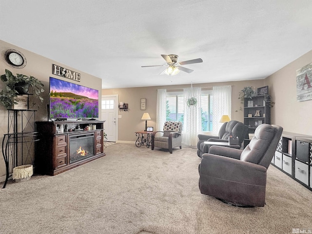 574 W National Ave, Winnemucca, NV 89445 - living room with carpet flooring, a ceiling fan, a glass covered fireplace, and baseboards