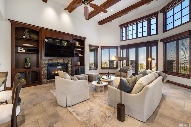 12360 High Vista Dr, Reno, NV 89511 - living area with beam ceiling, stone tile flooring, ceiling fan, a fireplace, and a high ceiling