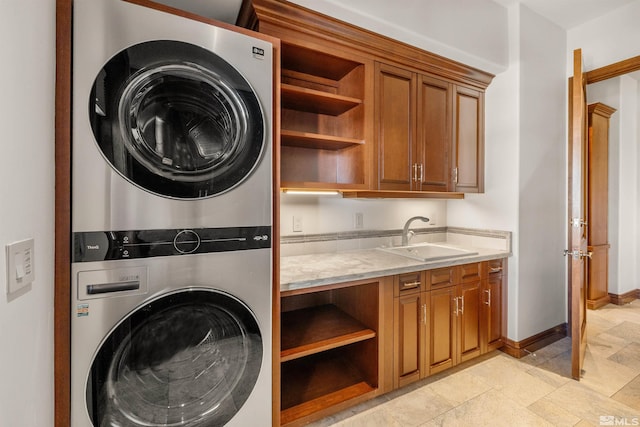 12360 High Vista Dr, Reno, NV 89511 - clothes washing area with stacked washer and clothes dryer, cabinet space, baseboards, and light stone finish floors