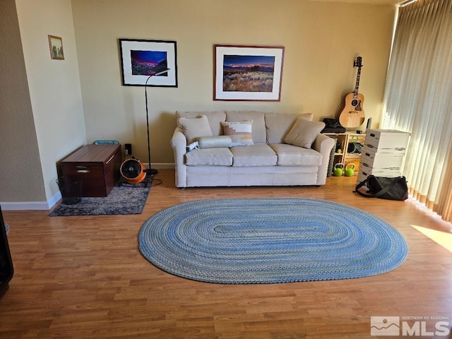 living area with baseboards and wood finished floors