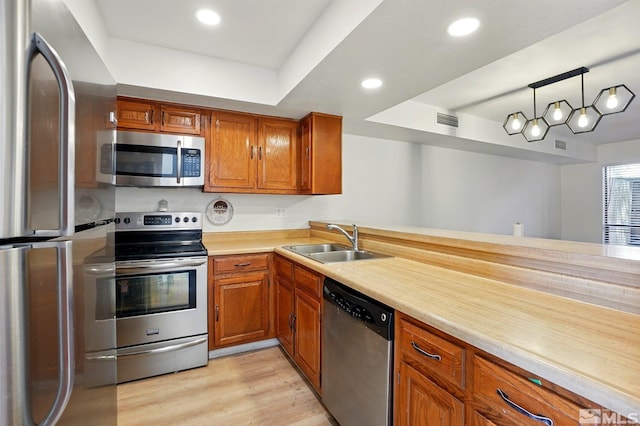4185 Baker Ln, Reno, NV 89509 - kitchen featuring appliances with stainless steel finishes, a sink, brown cabinets, light countertops, and light wood-style floors