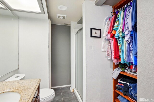 4185 Baker Ln, Reno, NV 89509 - full bathroom with tile patterned floors, a shower stall, vanity, and toilet