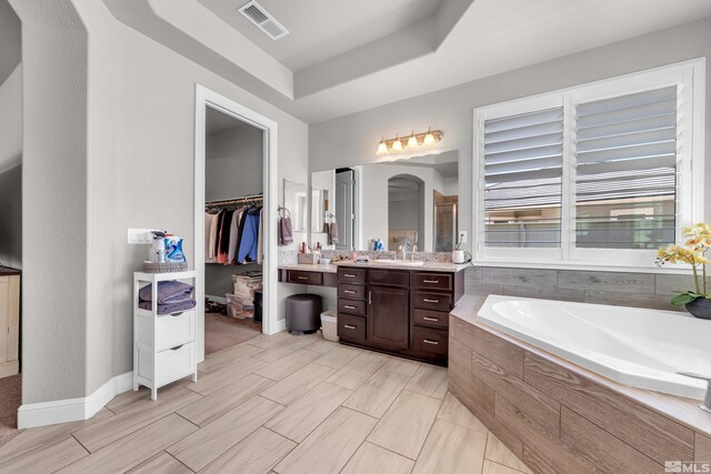 11641 Diamond Stream Dr, Sparks, NV 89441 - bathroom with a garden tub, vanity, a walk in closet, a raised ceiling, and a shower