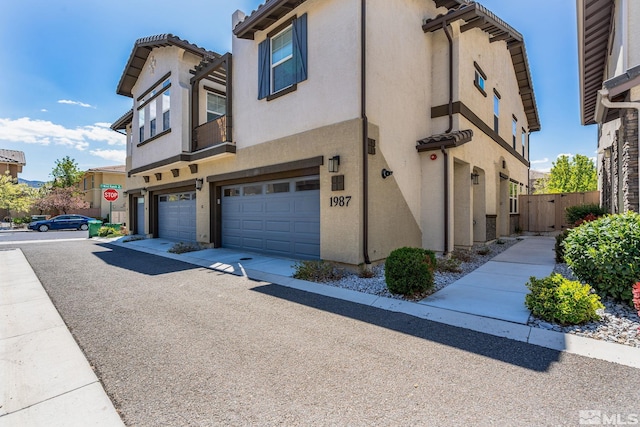 1987 Wind Ranch Rd Unit C, Reno, NV 89521 - view of property exterior with an attached garage, stucco siding, and fence