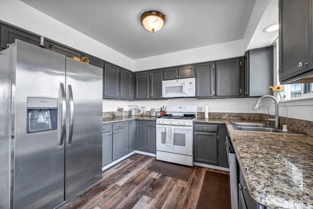 10205 Shenandoah Dr, Reno, NV 89508 - kitchen featuring white appliances, a sink, dark wood-style floors, and dark stone counters