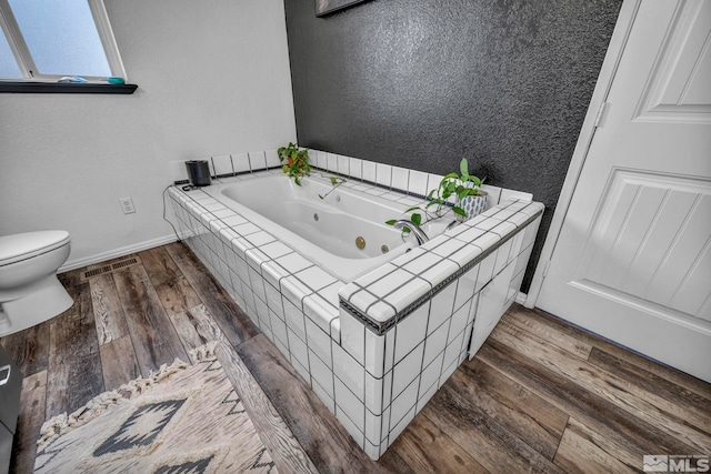 10205 Shenandoah Dr, Reno, NV 89508 - full bathroom with baseboards, wood finished floors, a whirlpool tub, and toilet