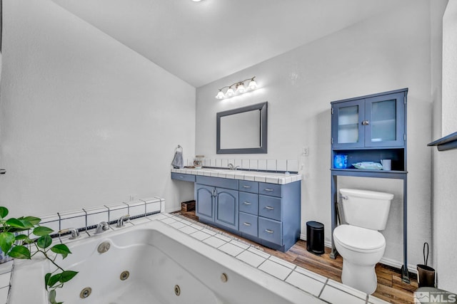 10205 Shenandoah Dr, Reno, NV 89508 - bathroom with toilet, vaulted ceiling, a jetted tub, vanity, and wood finished floors