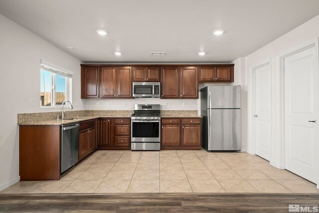 8971 Sagemoor Dr, Reno, NV 89506 - kitchen featuring appliances with stainless steel finishes, a sink, light stone countertops, and recessed lighting