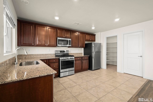 8971 Sagemoor Dr, Reno, NV 89506 - kitchen with stainless steel appliances, a sink, light stone counters, recessed lighting, and light tile patterned floors