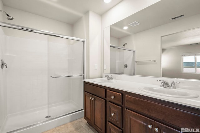 8971 Sagemoor Dr, Reno, NV 89506 - bathroom with a stall shower, double vanity, tile patterned floors, and recessed lighting