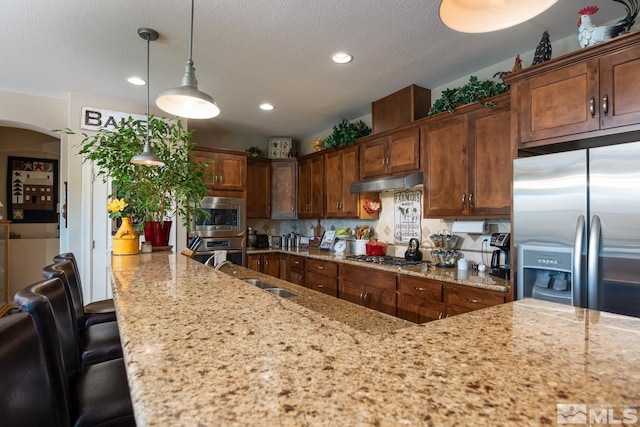 1058 Aspen Brook Ln, Gardnerville, NV 89460 - kitchen featuring a sink, appliances with stainless steel finishes, recessed lighting, light stone counters, and under cabinet range hood