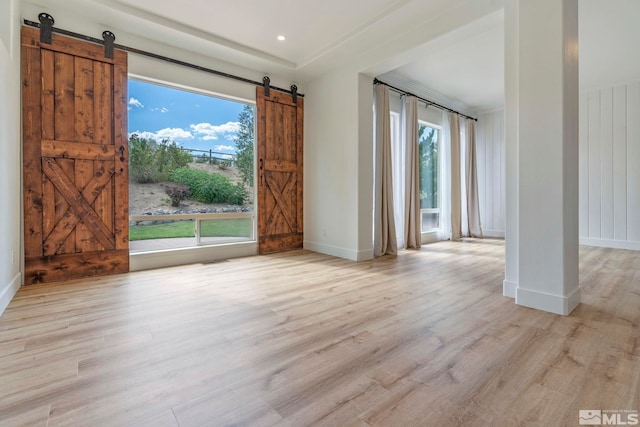 2705 Wind Feather Trl, Reno, NV 89511 - spare room with a barn door, healthy amount of natural light, wood finished floors, and baseboards