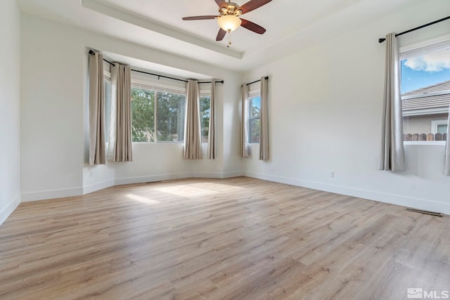 2705 Wind Feather Trl, Reno, NV 89511 - empty room with light wood-style flooring, a raised ceiling, ceiling fan, and baseboards