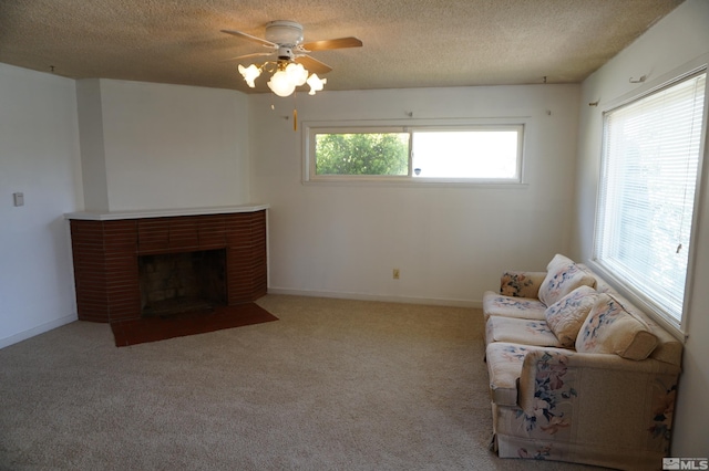 933 Cordone Ave, Reno, NV 89502 - carpeted living room with a textured ceiling, ceiling fan, a brick fireplace, and baseboards