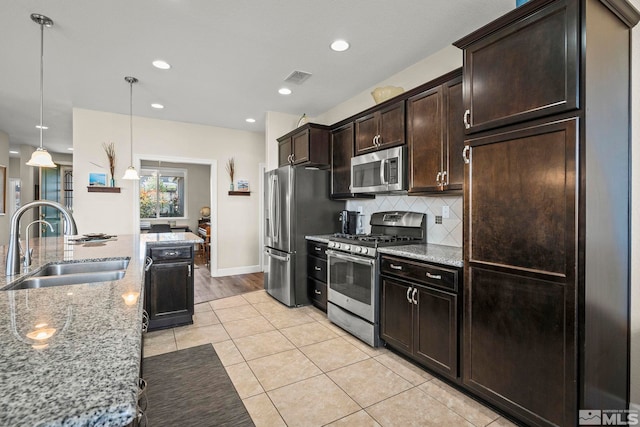 780 Ahwanee Dr, Sparks, NV 89436 - kitchen with appliances with stainless steel finishes, a sink, tasteful backsplash, dark brown cabinets, and light stone countertops