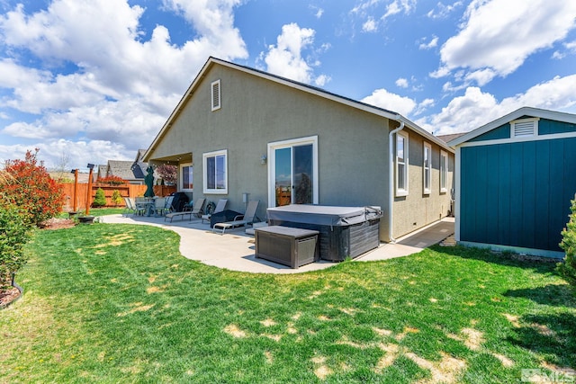 780 Ahwanee Dr, Sparks, NV 89436 - rear view of property featuring a hot tub, a patio area, stucco siding, an outdoor structure, and a storage shed