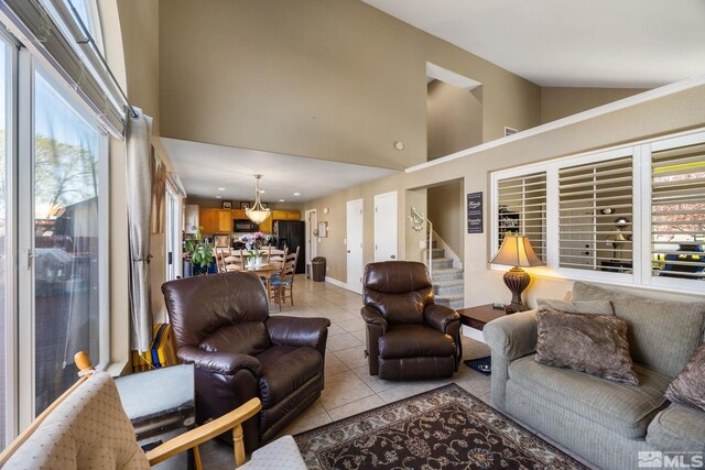 8127 Anchor Point Dr, Reno, NV 89506 - living area featuring light tile patterned floors, high vaulted ceiling, stairs, and baseboards