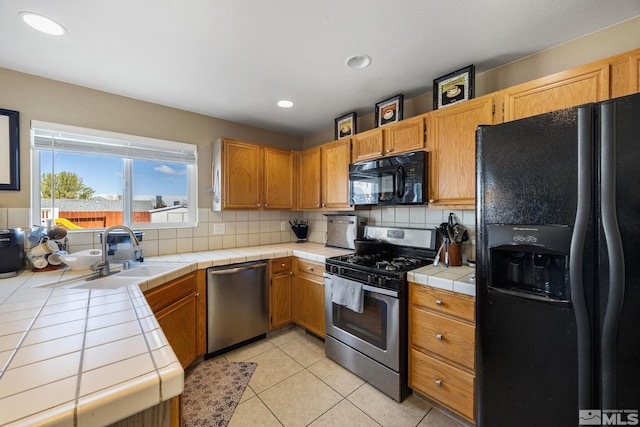 8127 Anchor Point Dr, Reno, NV 89506 - kitchen featuring black appliances, a sink, tile countertops, backsplash, and light tile patterned flooring