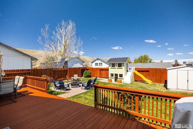 8127 Anchor Point Dr, Reno, NV 89506 - deck with an outdoor fire pit, a storage unit, an outbuilding, and a residential view