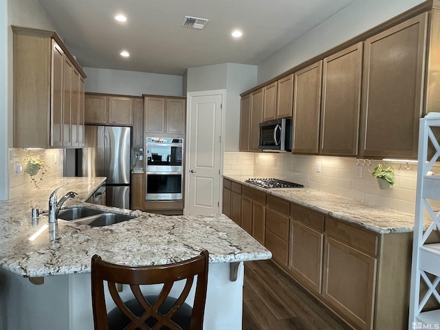 684 Rose Ln, Fernley, NV 89408 - kitchen featuring stainless steel appliances, a sink, a peninsula, dark wood finished floors, and a breakfast bar