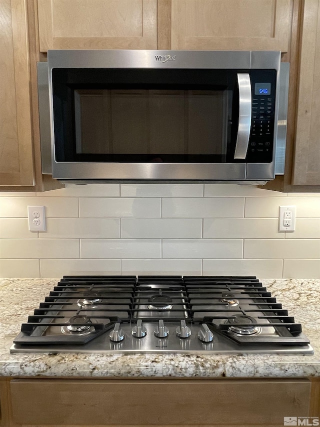684 Rose Ln, Fernley, NV 89408 - kitchen view of stainless steel appliances, tasteful backsplash, and light stone counters
