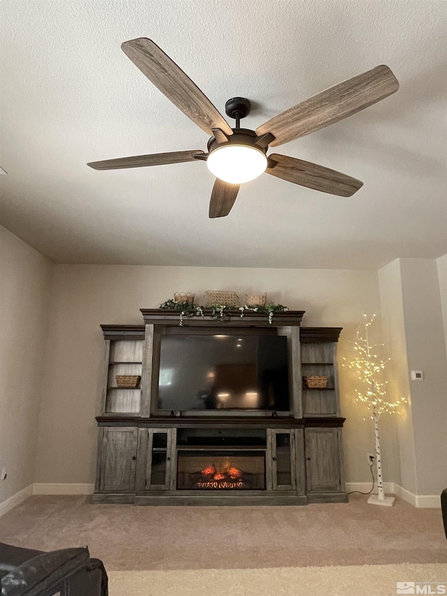 684 Rose Ln, Fernley, NV 89408 - living area featuring carpet flooring, a glass covered fireplace, ceiling fan, and baseboards