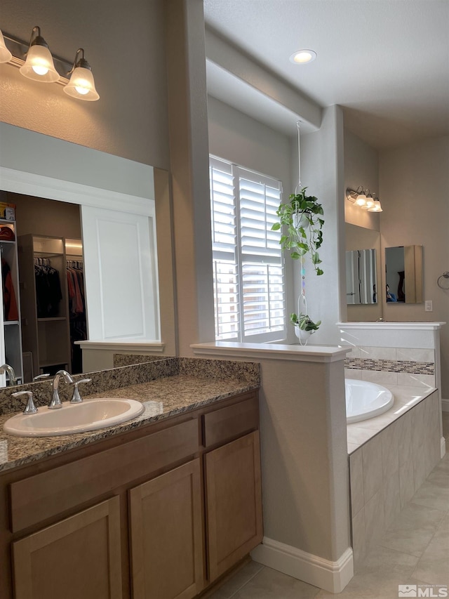 684 Rose Ln, Fernley, NV 89408 - bathroom with tile patterned floors, a spacious closet, a garden tub, and vanity